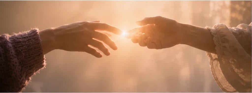 Duas mãos se aproximando com ternura na luz, um brilho quente entre elas — emoção intensa acolhida com compaixão