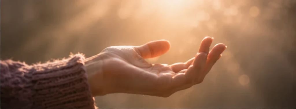 Mão se abrindo lentamente de um punho fechado em direção à luz quente — o alívio de soltar o ritual