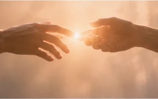 Duas mãos se aproximando com ternura na luz, um brilho quente entre elas — emoção intensa acolhida com compaixão